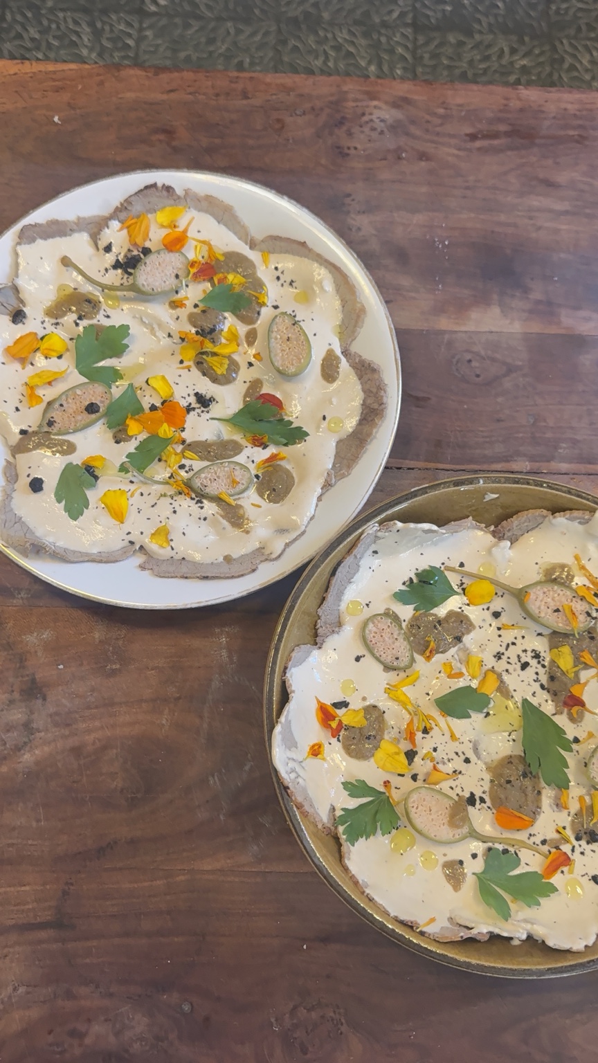 Vitello tonnato plated with herbs and flowers